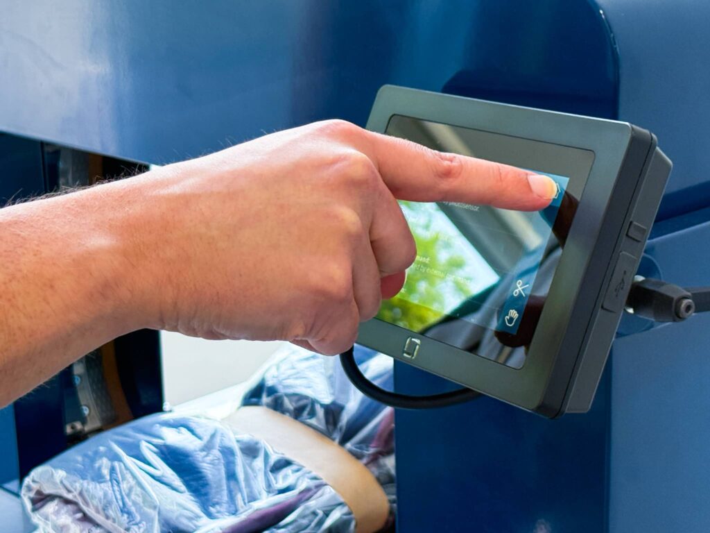 Operator pressing a button on the user-friendly touchscreen interface of the Felins US-3000 banding machine.
