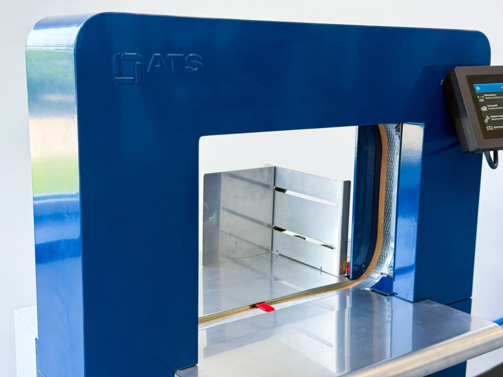 Full view of the Felins US-3000 banding machine with open arch and side-mounted touchscreen control panel.