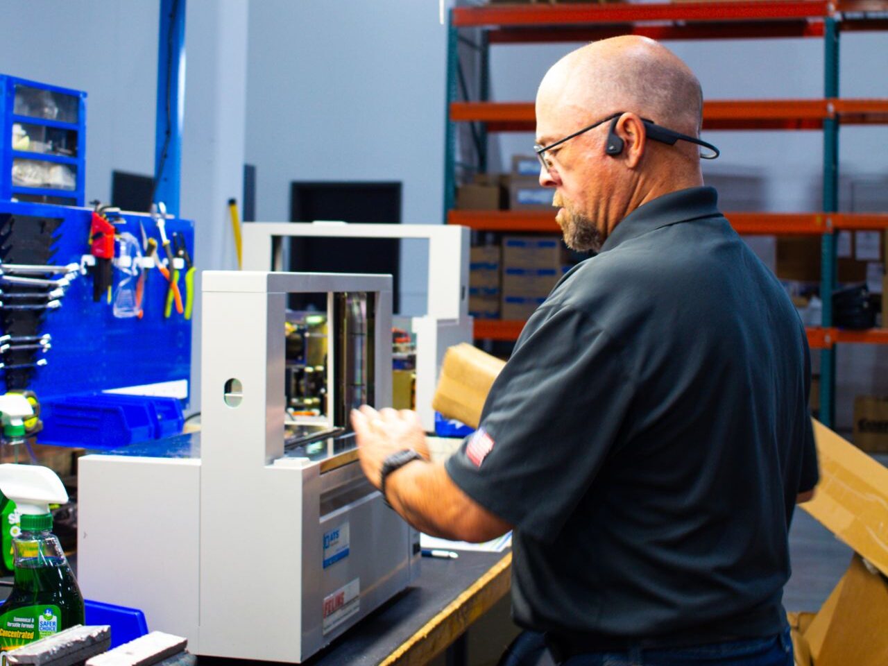 A Felins Service Technician inspects a tabletop machine unit